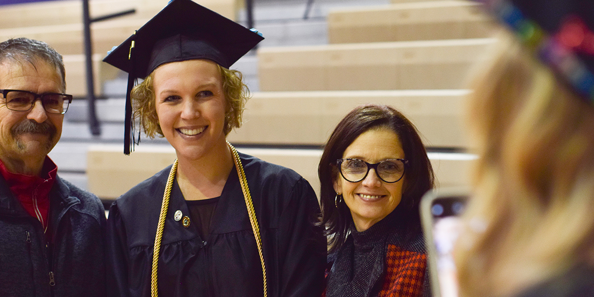 Student with parents at graduation