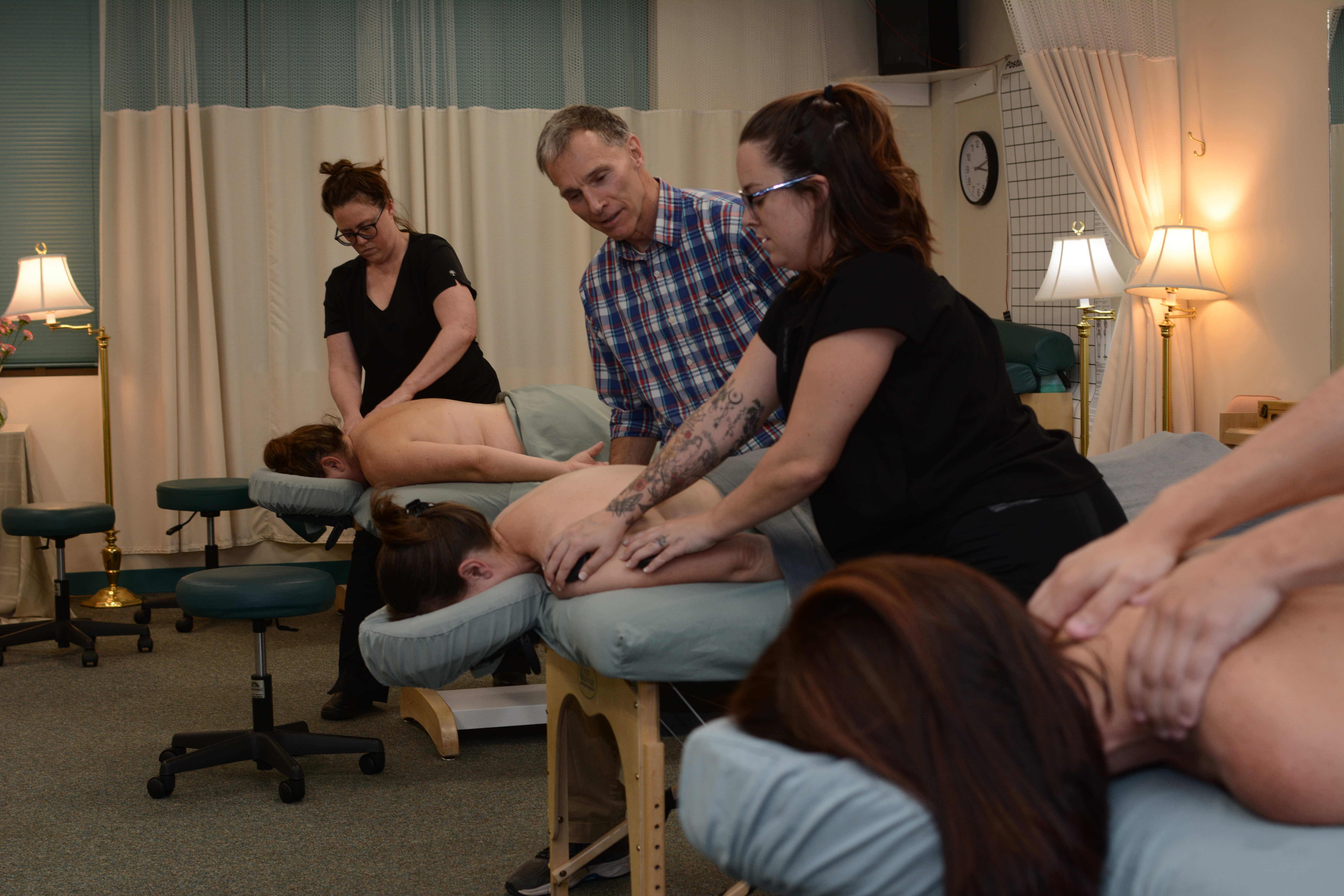 Student being instructed on how to massage shoulder. 