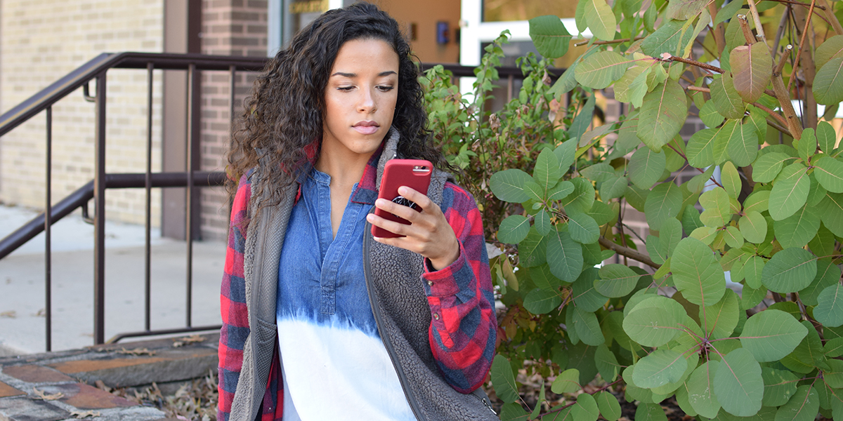 ACM Student looking at her phone