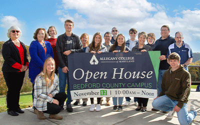 BCC students, faculty & staff gather outdoors with banner