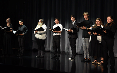 Choir is shown performing at Zimmer Theatre reopening