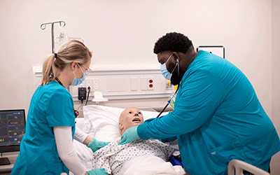 Nursing students check vitals in sim lab