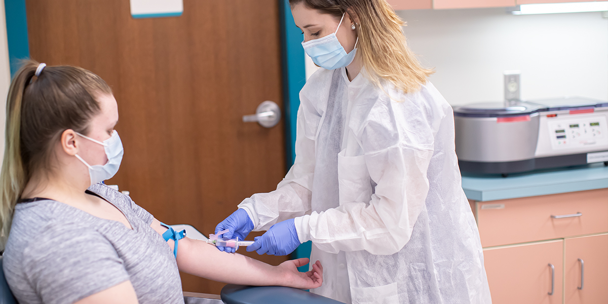 Student taking blood from another student