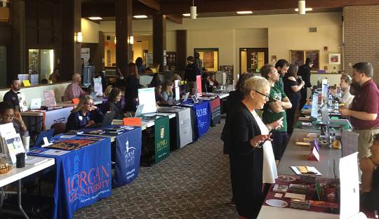 College Recruiters Sitting at Tables